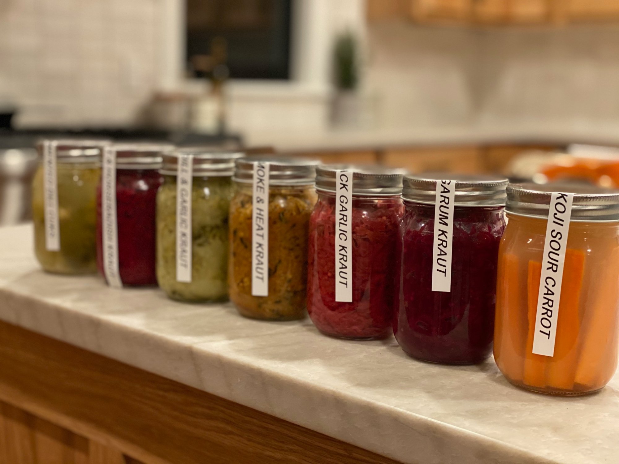 Longsummer Fine Foods kraut varieties lined up on marble counter